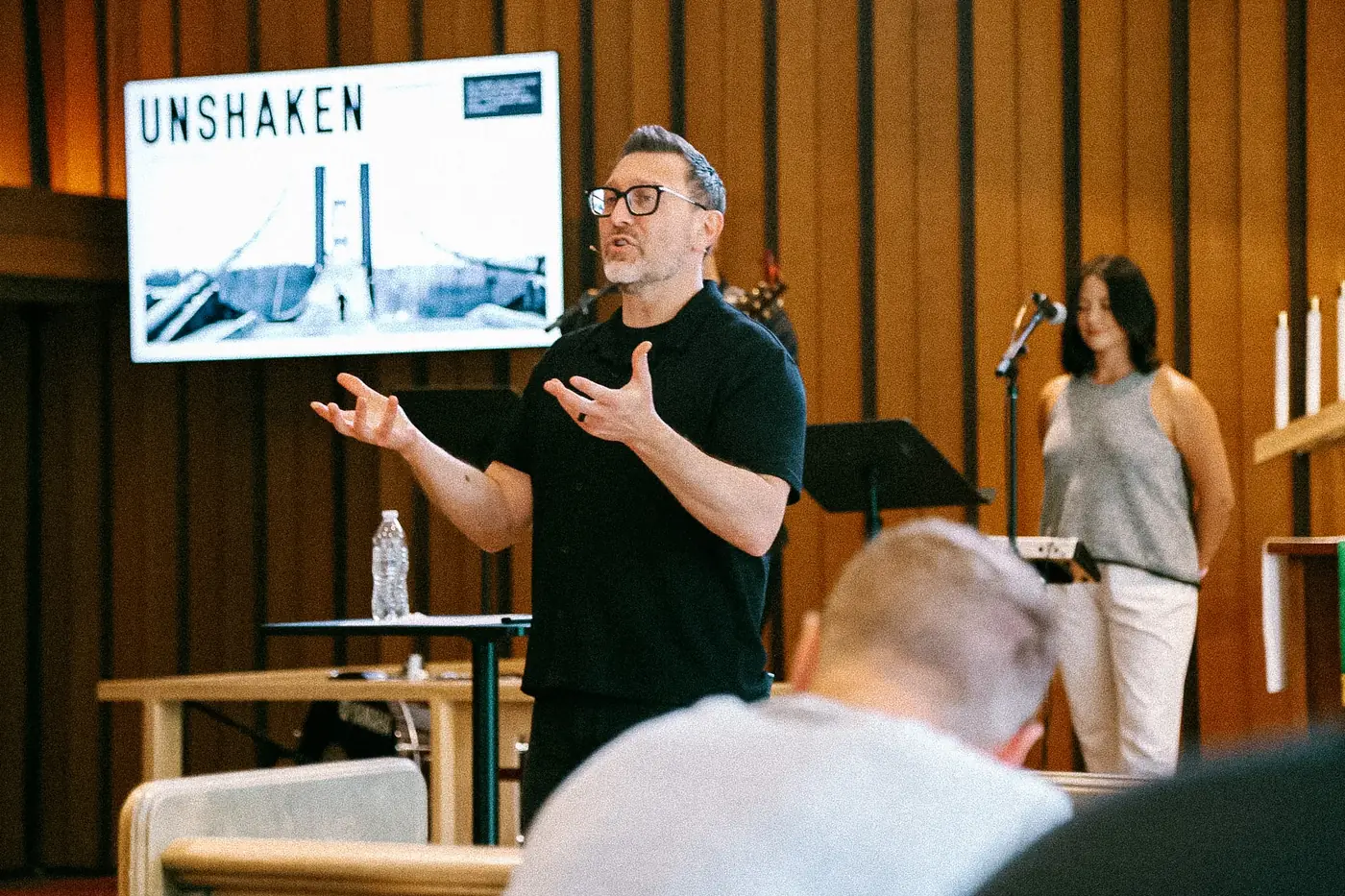 Bubba Jennings preaching in front of a screen showing the title of his sermon series, Unshaken